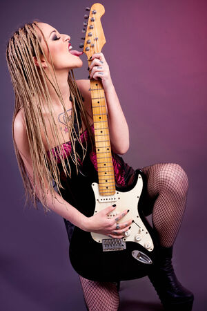 attractive punk girl with lots of tattoos and electric guitar の写真素材