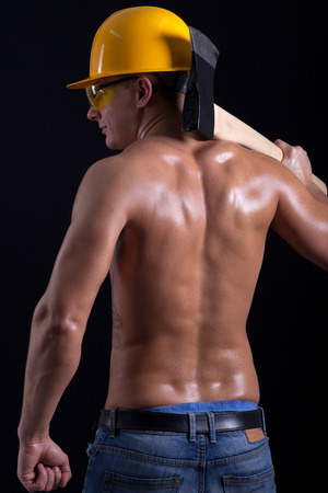 young muscular worker holding hatchetの写真素材