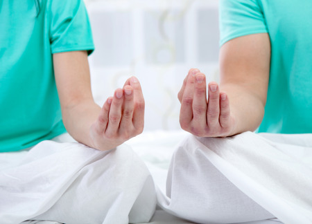 couple in bed together meditating の写真素材