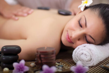 Beautiful woman having a wellness back massage at spa salon の写真素材