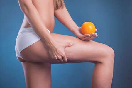 female body with orange on blue backgroundの写真素材