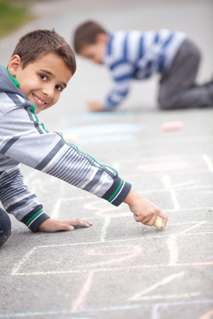  little boy drawing with chalk outdoorsの写真素材