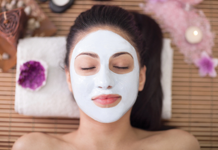 beautiful woman having facial mask at beauty salonの写真素材