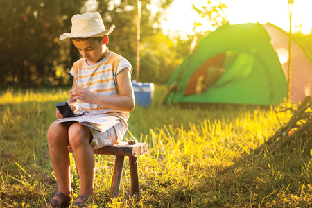 child on a camping learns to use a compassの写真素材