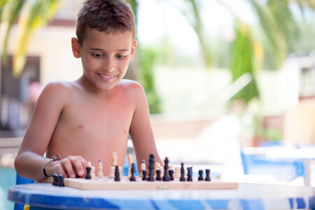 summer time, kid playing chess at seaの写真素材