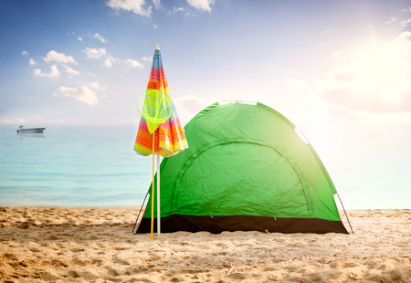 tent on beach at sunset,clouds sea and little ship in backgroundの写真素材