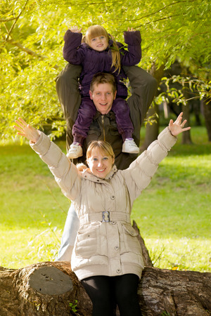 Happy mother, father and daughter playing in the parkの写真素材