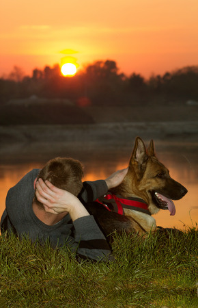 Man and Dog enjoying at  the river in sunsetの写真素材