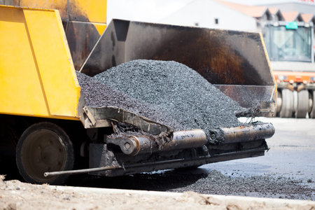 Tracked paver laying fresh asphalt