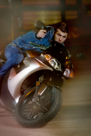 dangerous Biker with a gun suddenly enters the curvatureの写真素材