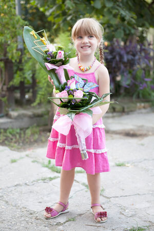 happy smiling little girl with a bouquet of flowersの写真素材