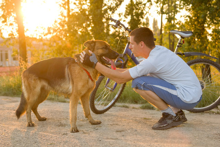 happy man with a dog in the park after a joint trainingの写真素材
