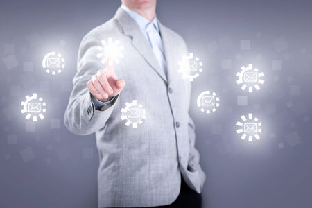 business man in gray suit on the virtual keyboard sends emailの写真素材