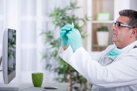 senior doctor preparing an injection in officeの写真素材