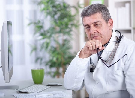 modern senior doctor with glasses in the officeの写真素材