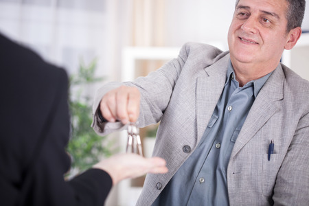 happy businessman  giving a key to new homeの写真素材