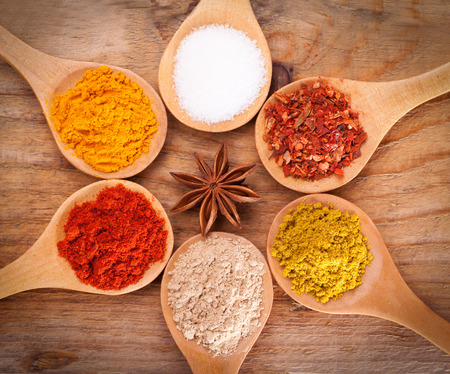 powder spices on spoons on wooden backgroundの写真素材