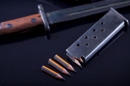 knife, pen in the form of bullet on black backgroundの写真素材