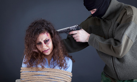 terrorists holding a gun to a woman's headの写真素材