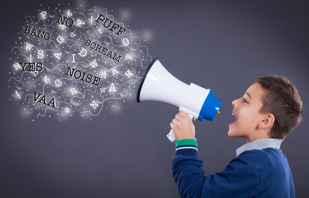 funny boy with a megaphone makes noiseの写真素材