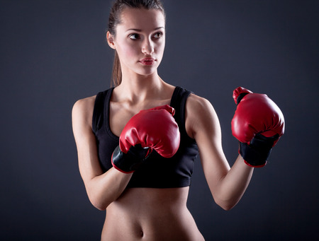 fit woman looking aggressive with boxing glovesの写真素材