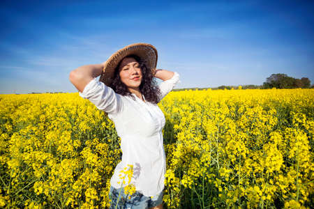 Beauty Romantic Girl Outdoors in canola fieldの写真素材