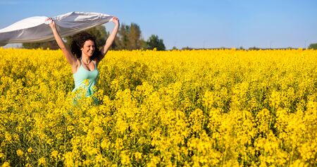 Woman with white piece of cloth in windの写真素材