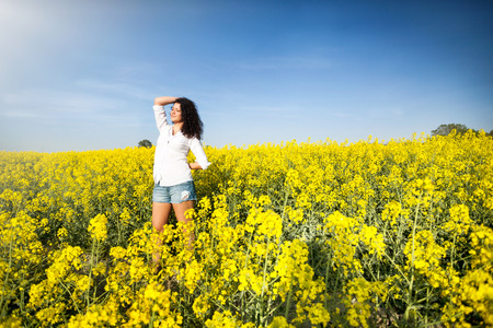 Beauty Romantic Girl Outdoors in canola fieldの写真素材