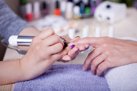 polishing fingernails by polish nail machineの写真素材
