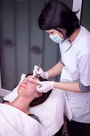 professional tattooist making eyebrow make upの写真素材