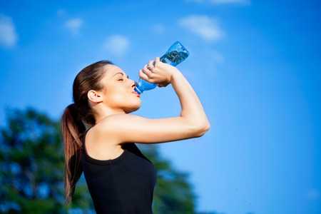 Portrait of young beautiful  woman drinking water at summerの写真素材