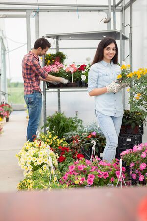 Young smiling people florists working in the gardenの写真素材