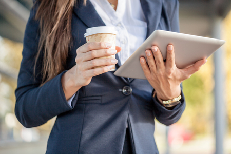 businesswoman on a coffee break holding electronic tabletの写真素材