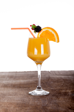fresh orange juice with a straw on woodの写真素材