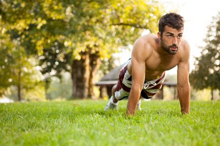 Male athlete exercising push up outsideの写真素材