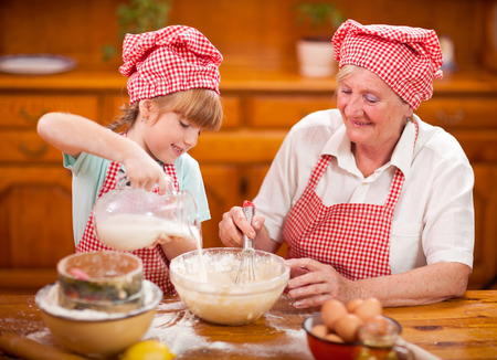 Grandmother and granddaughter baking cookies prepare doughの写真素材