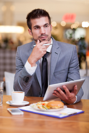 businessman in the restaurant  working on digital tabletの写真素材