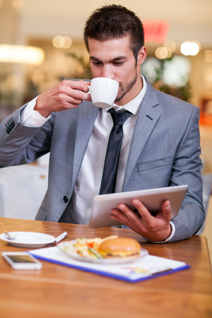 young businessman in the coffee break working on his laptopの写真素材