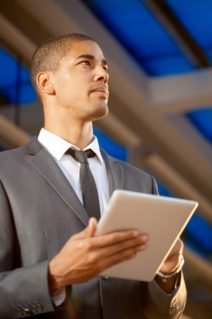 Successful business man with digital tablet outsideの写真素材