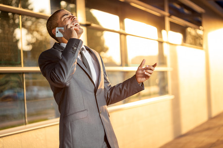 handsome businessman talking on mobile and smilingの写真素材