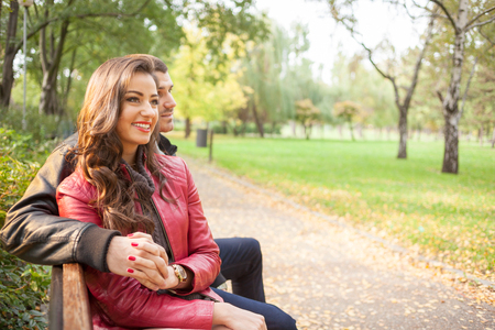romantic couple on a bench in park. Autumn setの写真素材