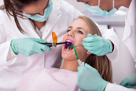 Dentist  examines the oral cavity of the patient on the dentist's chairの写真素材