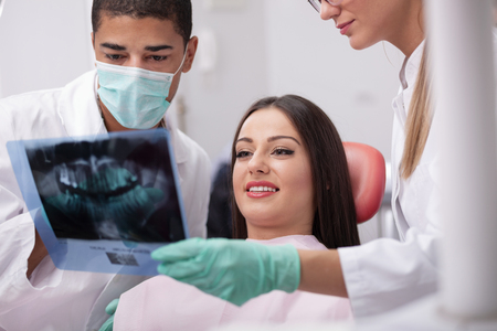 Dentist team and patient looking at x-ray imageの写真素材