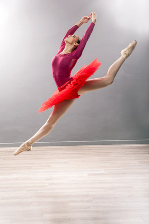 Ballerina is wearing a red tutu and pointe shoesの写真素材
