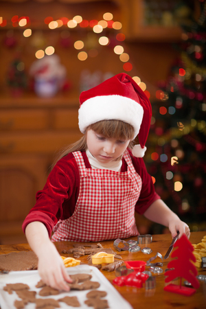 Happy young girl baking in kitchen Christmas cakesの写真素材
