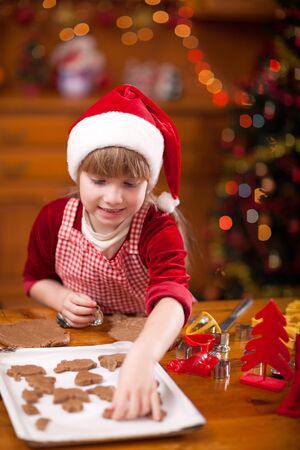 Happy young girl baking in kitchen Christmas cakesの写真素材