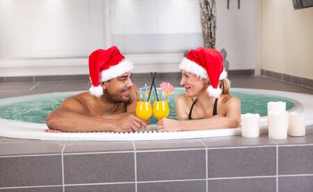 Happy christmas santa couple in hot tub. Vacationの写真素材