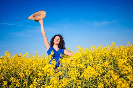 Beautiful woman in a yellow flowers fieldの写真素材