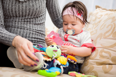 happy family. mother playing with her baby in the bedroomの写真素材