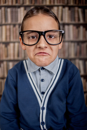 grumpy young boy in libraryの写真素材